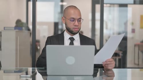 Man Celebrates Success at Desk with Laptop
