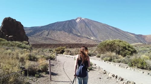 Tracking shot of woman with the background of the volcano Teide in the background.