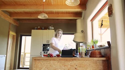 Woman Prepares Salad Following Online Recipe in Kitchen