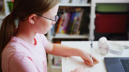 Child Writing and Studying at Desk at Home