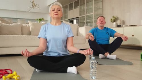 Senior Couple Meditating on Yoga Mats at Home