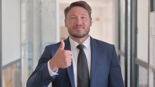Mature Adult in Suit Gives Thumbs Up