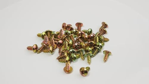 Metal screws on a white background. Rotating screws for driving into plastic.