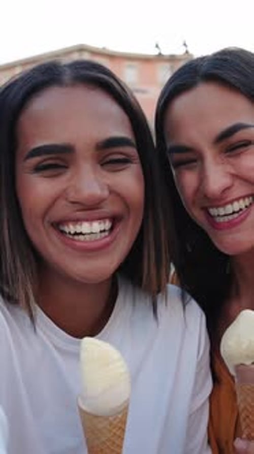 Three Happy Female Friends Taking a Selfie While Eating Ice Cream in a Town Square