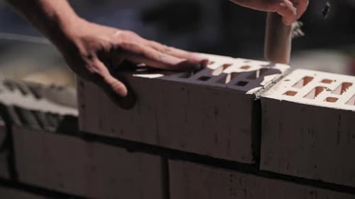 A Builder Lays Bricks at a Construction Site a Closeup of the Worker Hands