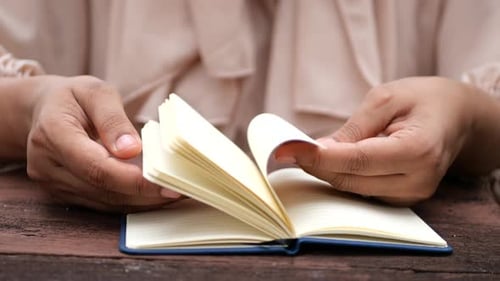 Close Up of Women Hand Turning a Pager of a Diary