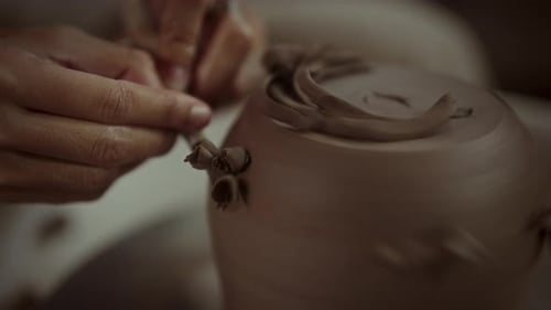 Artisan Shaping Pottery With Loop Tool For Final Touches On Wheel