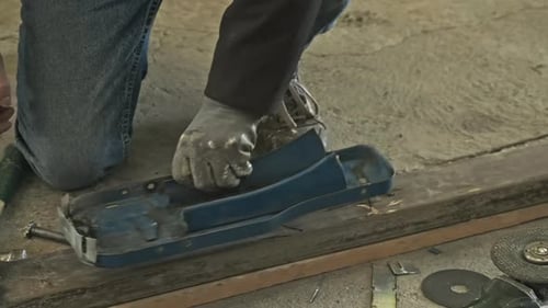 Close Up Of A Skilled Worker Working On A Piece Of Metal With Pliers In An Industrial Workshop - slo