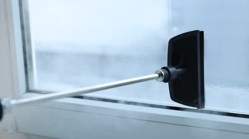 Fenster mit Dampfreiniger zu Hause putzen, Nahaufnahme. Kamera bewegt sich nach links