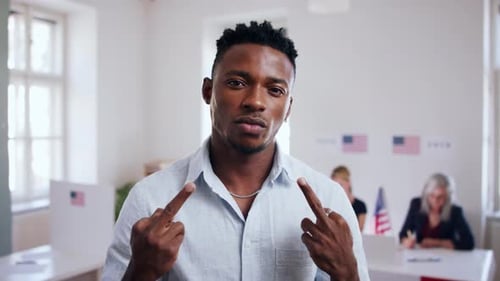 Furious african american voter flips off camera in USA polling place during elections