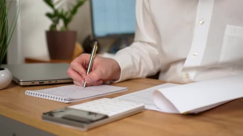 Businessman Sitting at Desk and Writing on Piece of Paper Close Up Man is Working in Office