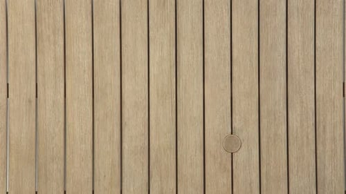Top-down view of textured wooden slat patio table surface
