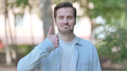 Man Gives Thumbs Up Gesture Outdoors
