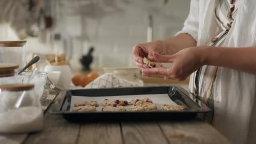 Woman Prepares Raw Cookies in Bright Kitchen