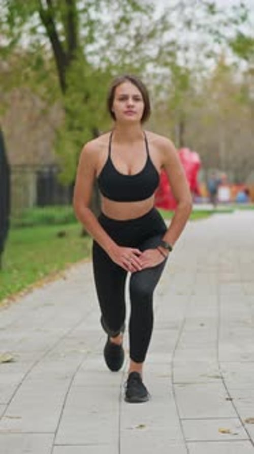 Athlete Woman Stretching Legs Outdoors in Game Park Performing Lunges