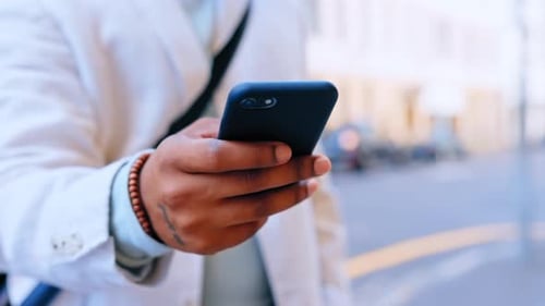 Hands, phone and typing in city for social media, texting or web scrolling outdoors in street