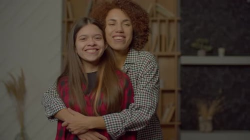 Portrait of Smiling African American Mom and Cute Teenage Daughter Embracing