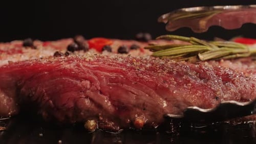 Fresh Marbled Beef with Pepper Salt and Rosemary Closeup Macro Cooking Juicy Steak on Grill with Oil
