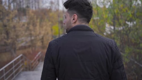 Man Walking Down Stairs in Urban Park