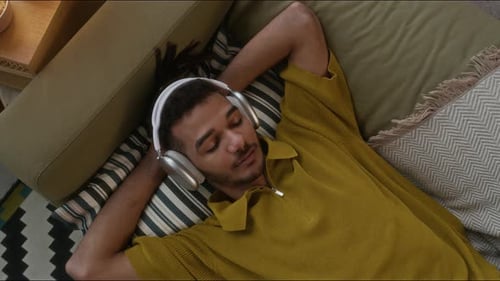 Young Biracial Guy Enjoying Relaxing Music at Home