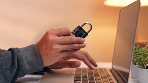 A hacker examines a padlock.