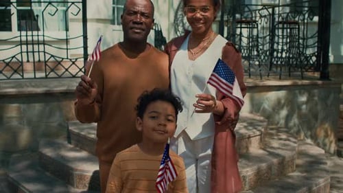 Family Holding American Flags on Front Steps