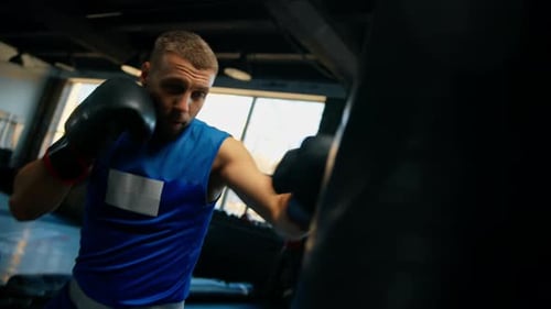 Boxing gym a boxer trains his punches hitting a punching bag