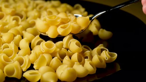 Taking Pasta from Plate with Spoon – Close Up Food Shot