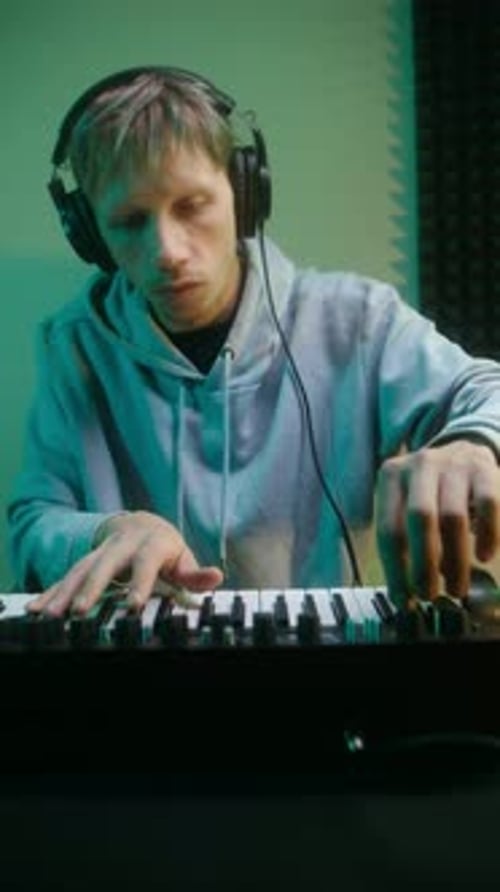 Young Music Producer Playing a Midi Keyboard in His Home Studio