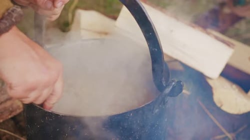 Close up preparing the dish in a pot on campfire. Medieval fair