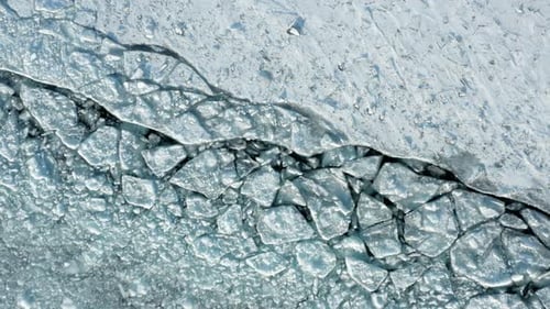 Aerial top down, cracked polar ice sheet path caused by icebreaker ship