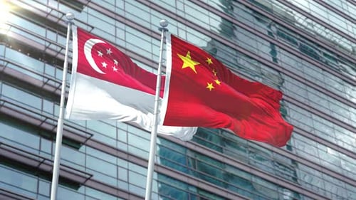 Singapore and China Flags Waving on Corporate Building Background