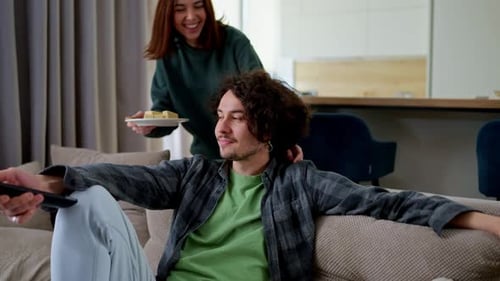 Couple Relaxing at Home with Cookies and TV