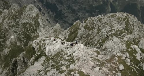 Drone shot of top of moutanin Rombon, birdseye perspective, group of hikers climbing up the mountain