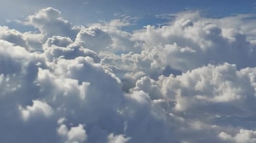 Luftbild, das durch dicke weiße, flauschige Wolken unter B fliegt
