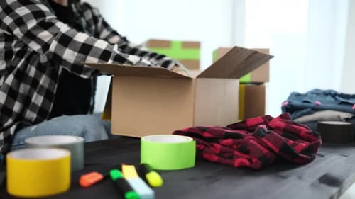 Girl Packing Packing A Cardboard Box For Shipping