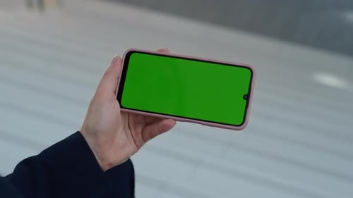 Hand Holding Phone with Green Screen for Compositing