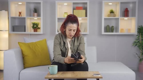 Distressed Woman Checking Empty Wallet on Sofa