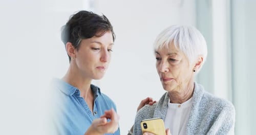 Senior Woman and Adult Looking at a Cellphone
