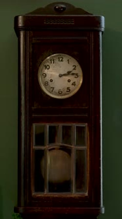 An Old Vintage Clock with the Pendulum Swinging