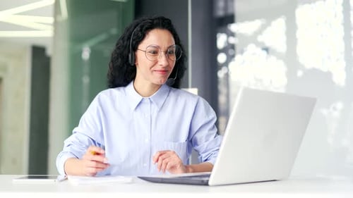 Woman Video Calling on Laptop in Office Environment