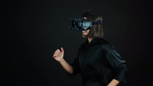 Young Woman With Goggles Running in Virtual Reality, VR Video Gaming Concept, Black Background