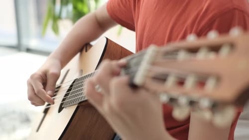 Close Up of Young Guy Playing Guitar in His Room