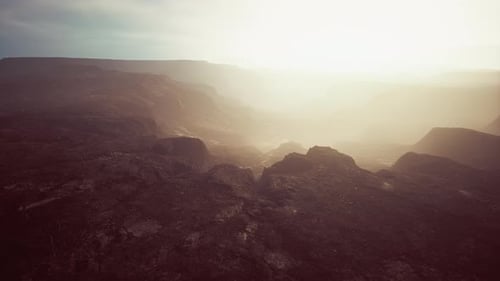 Hazy Sunrise Over Vast Rocky Canyon Landscape
