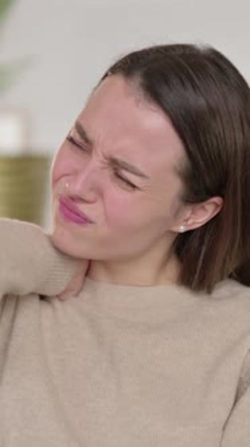 Young Woman Massaging Her Aching Neck in Pain