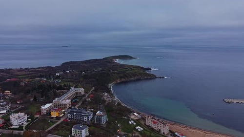 Coastal view of a beach area with buildings and green spaces in sight