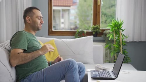 Man Meditating on Couch at Home
