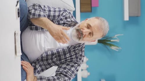Vertical video of The grieving old man is thinking and suffering from depression.