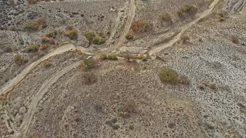 Aerial over off road 4x4 car driving along gravel trail path
