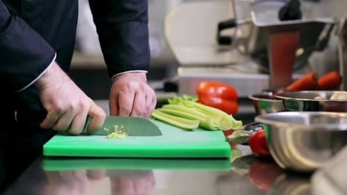 Chef Dicing Celery Finely on Green Cutting Board